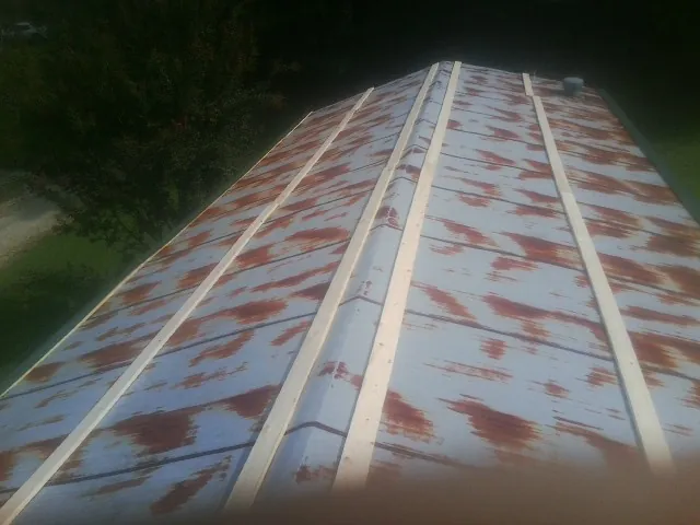 Rusted metal roof panels with new wood purlins before replacement — Storm Damage Roof Repair in Hye by Roofing Brothers